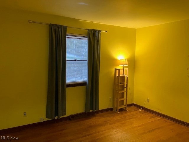 spare room featuring wood finished floors and baseboards