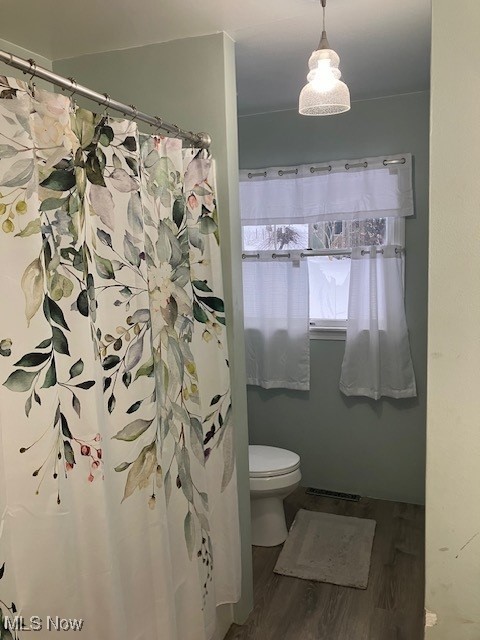 full bathroom featuring visible vents, toilet, and wood finished floors