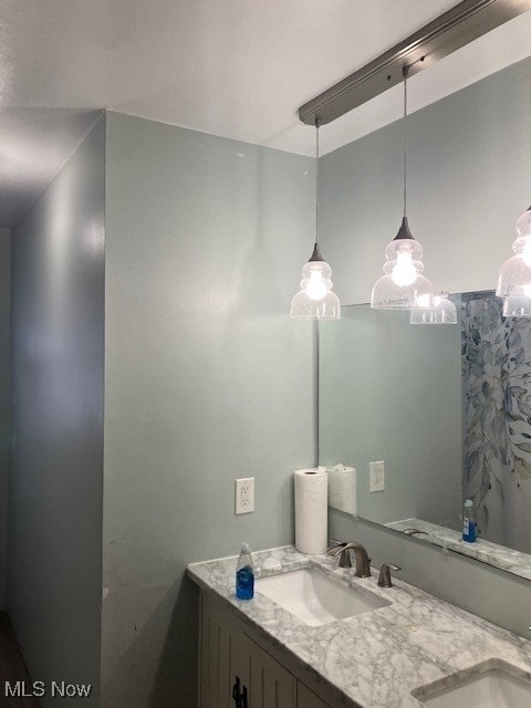 bathroom featuring a sink and double vanity