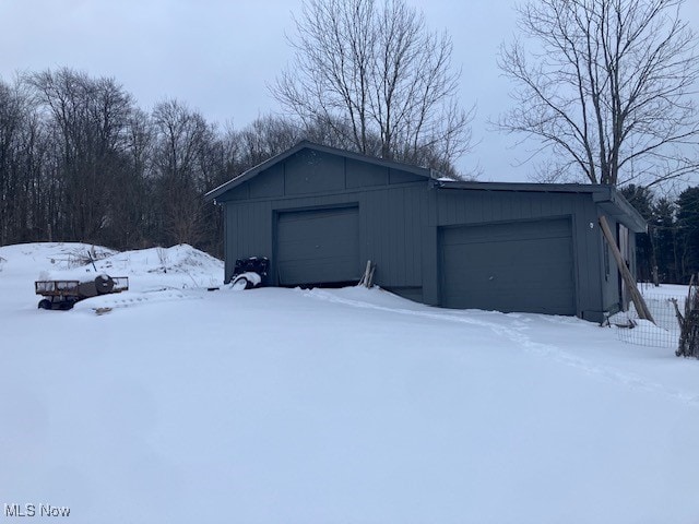 snow covered garage with a garage