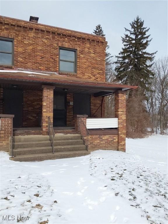 view of front facade with covered porch and brick siding