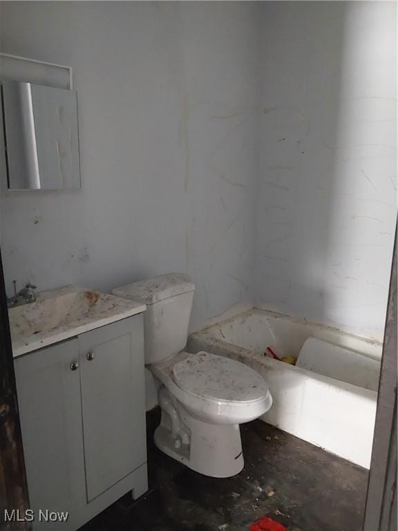 bathroom with toilet, vanity, and a bath