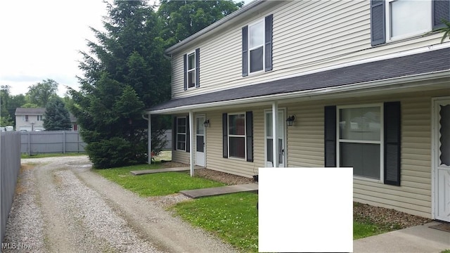 view of front of home featuring covered porch and fence