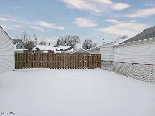 yard covered in snow featuring fence