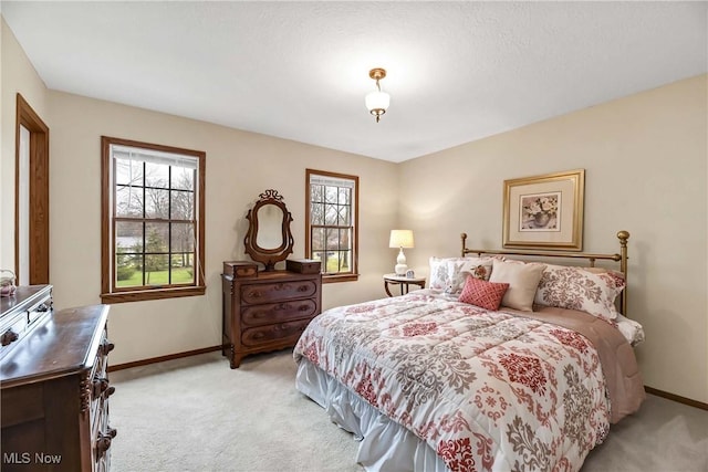 bedroom with baseboards and light colored carpet