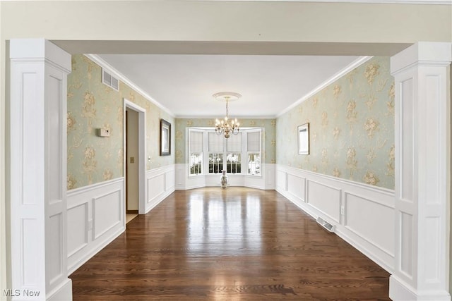 unfurnished dining area featuring a wainscoted wall, visible vents, and wallpapered walls