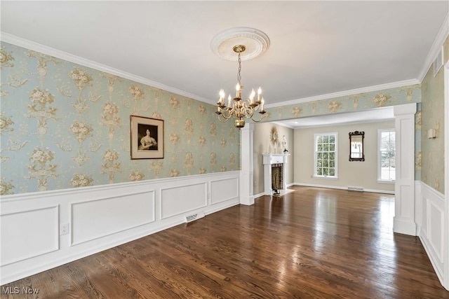 interior space featuring wallpapered walls, visible vents, a wainscoted wall, a fireplace with flush hearth, and wood finished floors