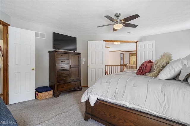 bedroom with a ceiling fan, visible vents, and light colored carpet