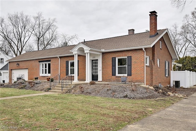 view of front of home featuring brick siding, a chimney, central air condition unit, an attached garage, and a front lawn