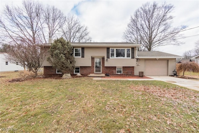 split foyer home featuring driveway, an attached garage, a front lawn, and brick siding