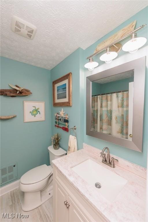 full bath featuring a textured ceiling, toilet, vanity, and visible vents