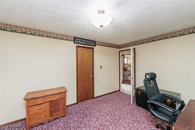 home office featuring a textured ceiling, carpet flooring, and baseboards