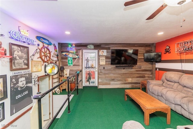 carpeted living area featuring recessed lighting, a ceiling fan, and wooden walls