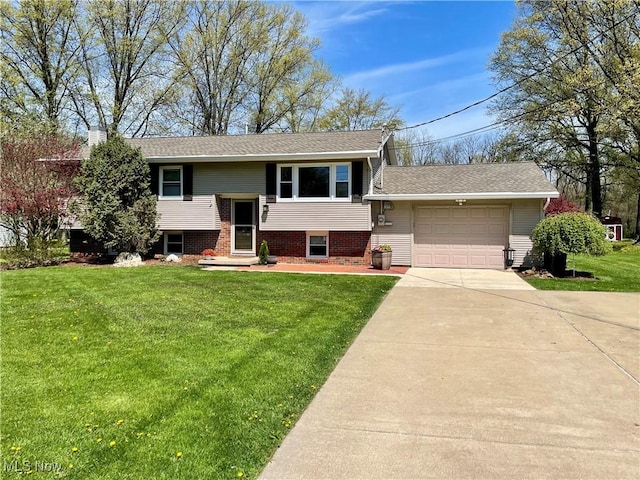 split foyer home with a front yard, a shingled roof, driveway, and an attached garage