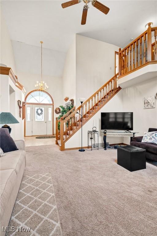 1925 N Lipkey Rd, North Jackson, OH 44451 - living area with high vaulted ceiling, stairway, a ceiling fan, carpet, and a chandelier