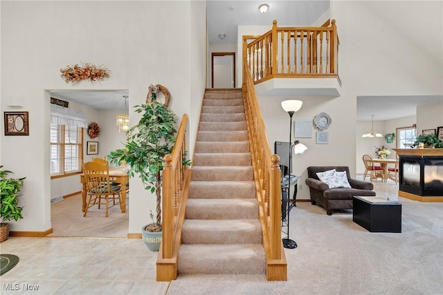 1925 N Lipkey Rd, North Jackson, OH 44451 - stairs featuring plenty of natural light, carpet floors, baseboards, a chandelier, and a towering ceiling