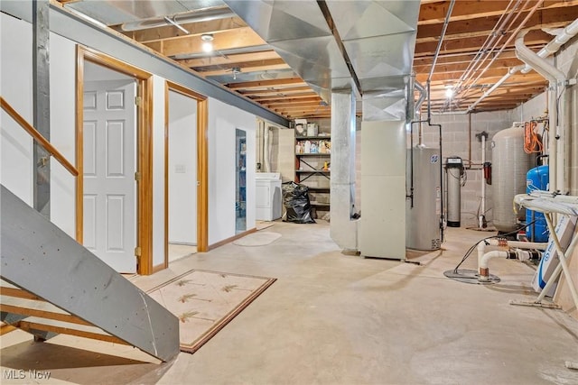 unfinished basement featuring water heater, washer / clothes dryer, and heating unit