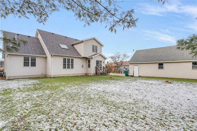 rear view of property featuring entry steps and roof with shingles