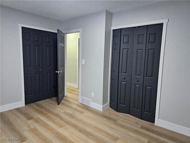 bedroom featuring light wood-style floors, baseboards, and visible vents