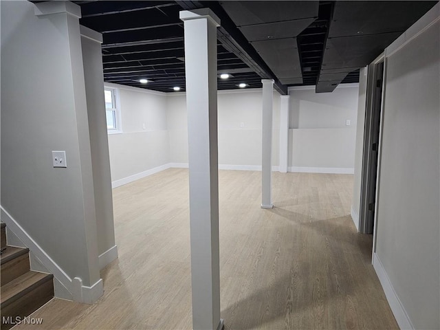 basement with baseboards, stairway, and wood finished floors