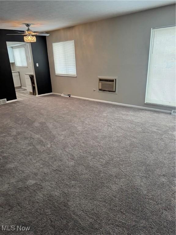 carpeted spare room featuring visible vents, ceiling fan, and baseboards