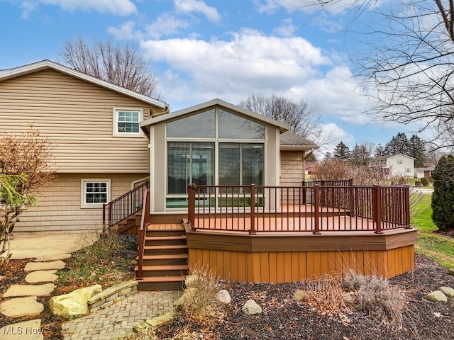 rear view of house with a wooden deck and stairs