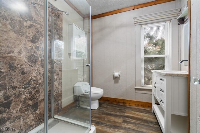 full bath with wood finished floors, toilet, a shower stall, a textured ceiling, and vanity