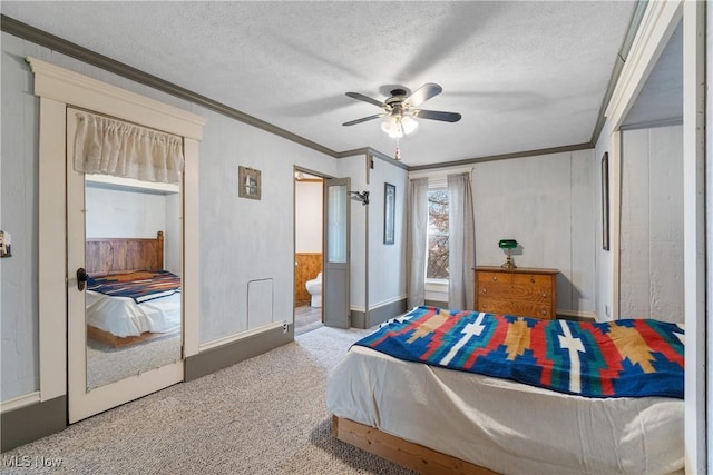 bedroom with a textured ceiling, carpet floors, ornamental molding, and a ceiling fan