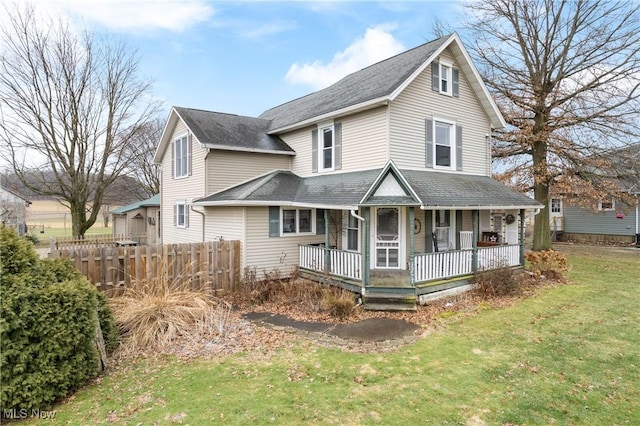 view of front of property featuring a porch, a front yard, and fence