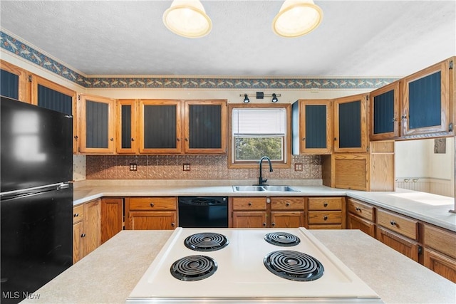 kitchen featuring glass insert cabinets, light countertops, a sink, and black appliances