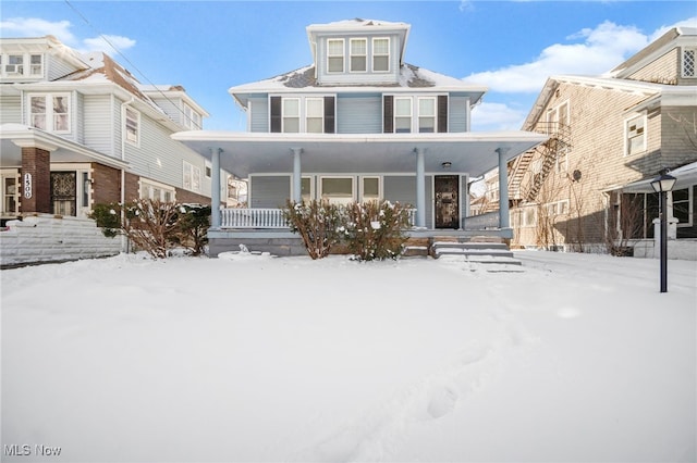 american foursquare style home featuring covered porch