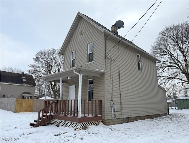 view of front facade featuring a chimney and fence