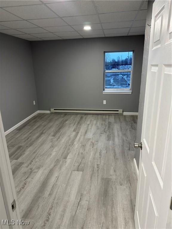 bathroom featuring a drop ceiling, toilet, wood finished floors, baseboard heating, and vanity