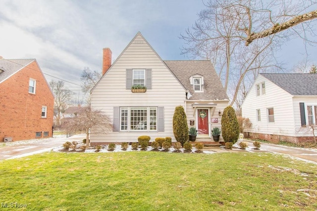 view of front of home featuring a shingled roof, a chimney, and a front lawn