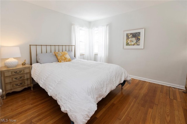 bedroom featuring baseboards and dark wood finished floors