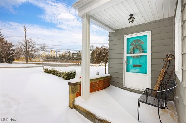 snow covered patio with a porch