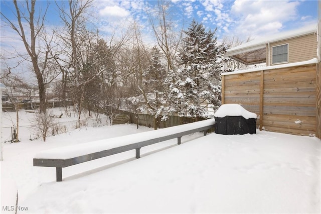 yard layered in snow featuring fence