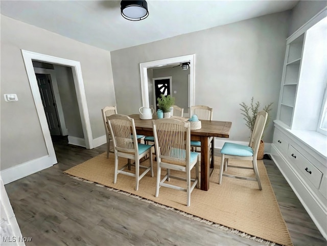 dining space with baseboards and dark wood finished floors