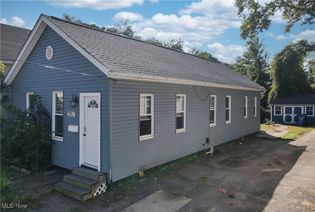 view of front facade with entry steps and roof with shingles