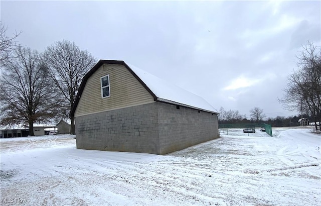 view of snowy exterior with a gambrel roof