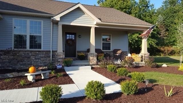 view of front of home with stone siding and a porch