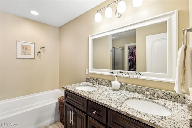 bathroom with a shower with door, double vanity, a garden tub, and a sink