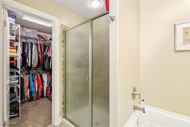 bathroom featuring a shower stall, a spacious closet, and a bath