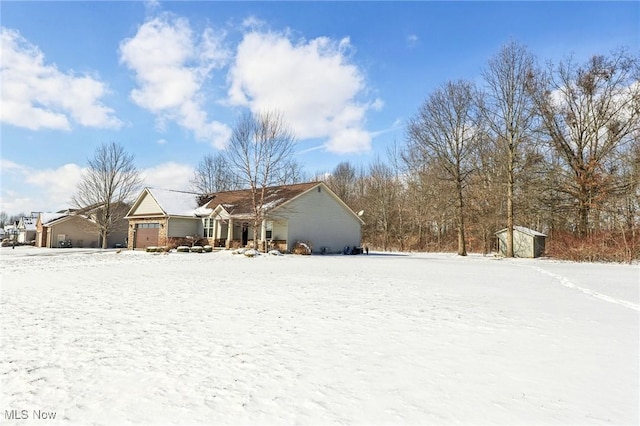 view of front of home with a shed and an attached garage