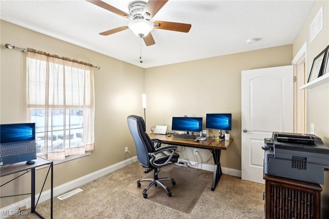 office featuring a healthy amount of sunlight, visible vents, light carpet, and baseboards