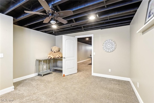 finished basement with ceiling fan, baseboards, and carpet floors