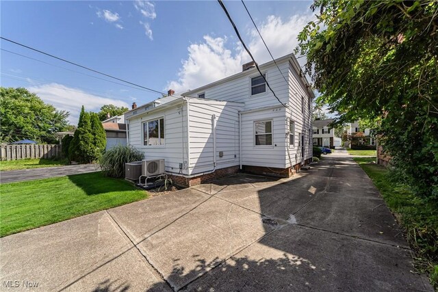 rear view of property featuring ac unit, fence, a patio, and a yard