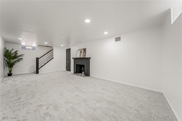 below grade area with visible vents, stairway, carpet, a fireplace, and recessed lighting