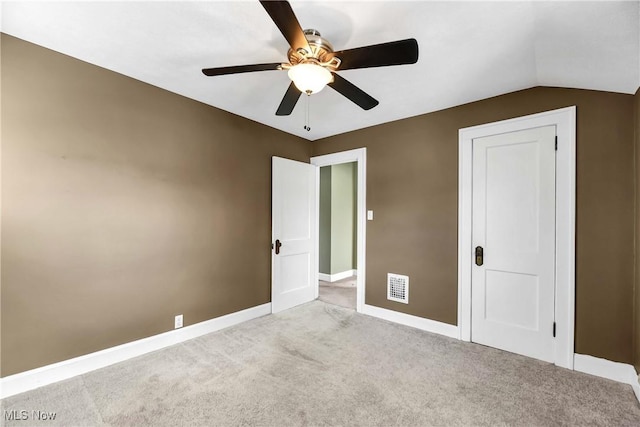 unfurnished bedroom with light carpet, baseboards, visible vents, a ceiling fan, and lofted ceiling