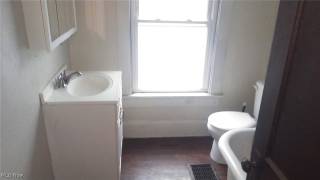 bathroom with toilet, visible vents, and vanity